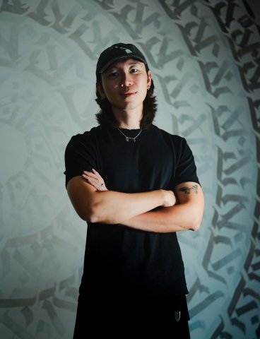 A couple sits on a rock, gazing at a scenic valley below